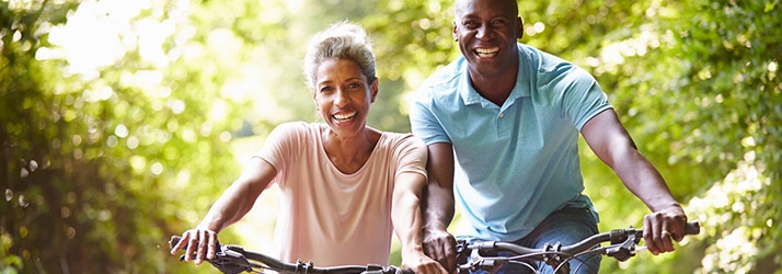 Happy Couple Biking In The Sun